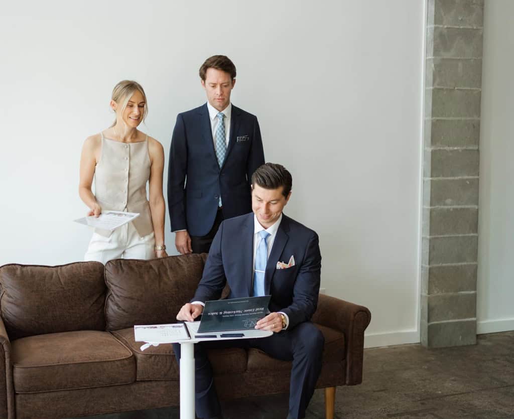Real estate professionals from North Pacific Homes Group discussing Victoria’s 2050 Official Community Plan in a modern office setting.