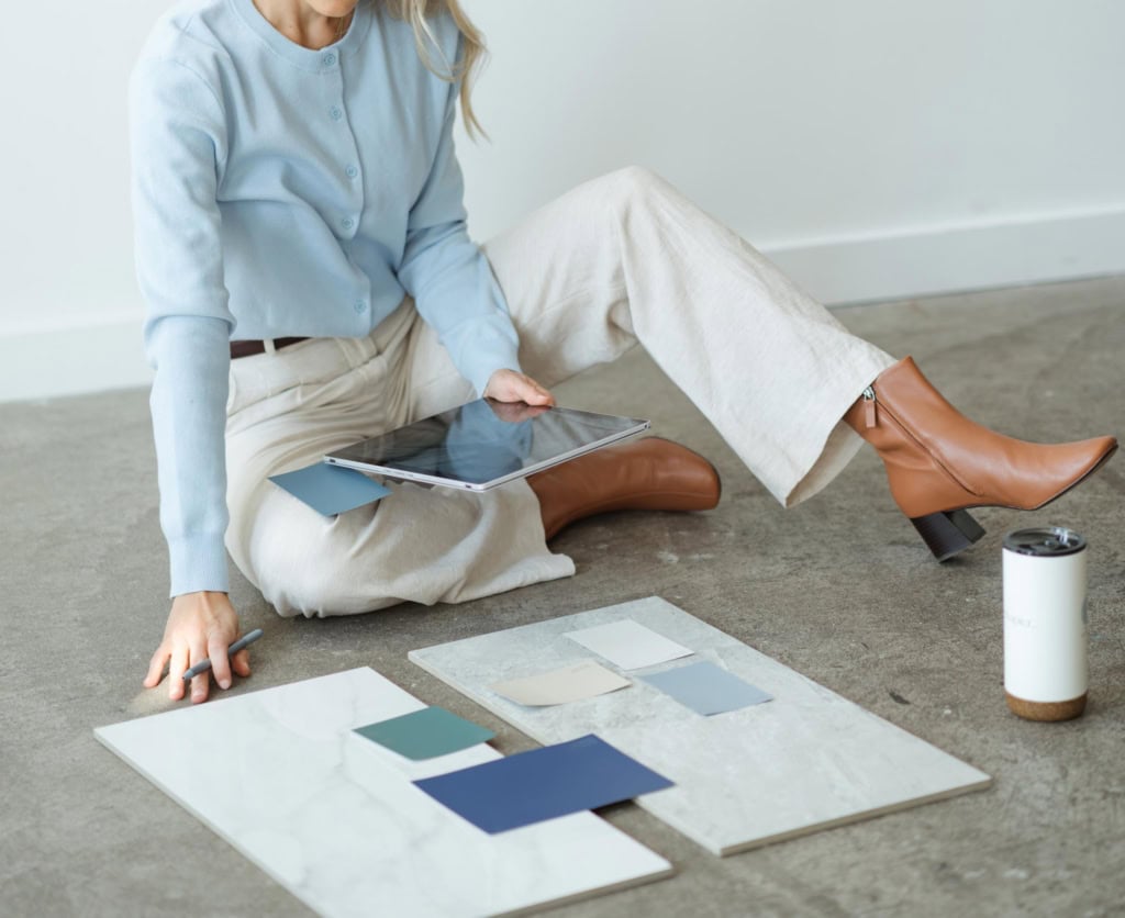 Homebuyer reviewing renovation materials and design samples on the floor while planning a fixer-upper project in Victoria, BC.